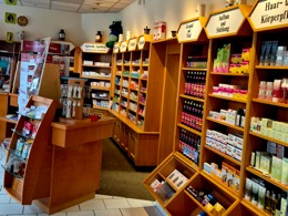 Innenansicht einer Apotheke mit Regalen für Gesundheitsprodukte, Pflegeartikel und Beratungsbereich.