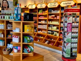 Innenansicht einer Apotheke mit Regalen für Kosmetik, Hautpflege und freiverkäufliche Produkte im Freiwahlbereich.